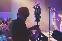 Media team member with camera live streaming a church concert