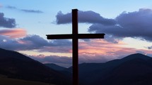 Timelapse of wooden cross on a rural landscape at dusk.

