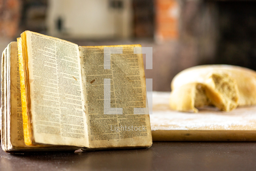Old Bible near bread loaves