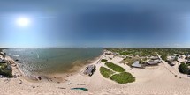 360 aerial photo taken with drone of kite surfing next to beachside restaurants in Lençóis Maranhenses in the afternoon on the northern coast of Brazil