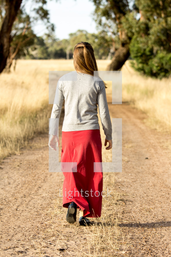 Girl Walking Down Dirt Road
