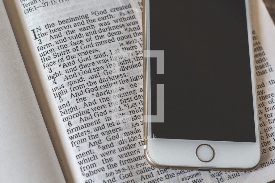 cellphone on the pages of a Bible 