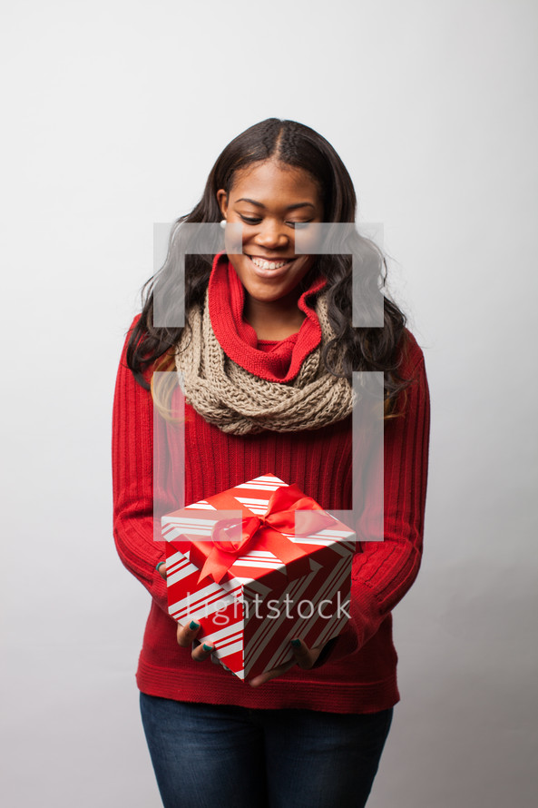 A woman holding a wrapped Christmas gift. 