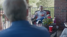 men sitting on a porch talking 