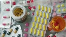 Close-Up of Various Medications, Pill Bottles and Blister Packs on the Table
