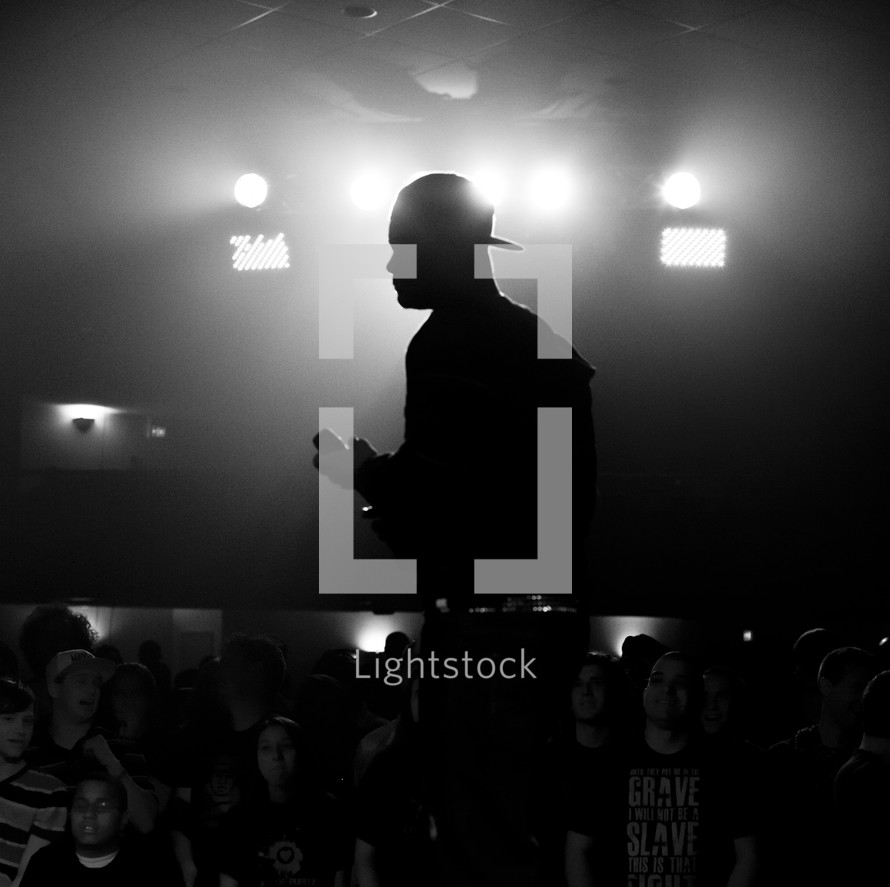 silhouette of a man holding a microphone