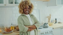 Portrait of SmilingAfrican American Woman with Arms Crossed in Kitchen
