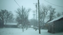 Snowflakes falling on in small town in cinematic slow motion in Christmas, winter, snow storm.