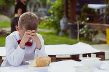 child praying before his meal 