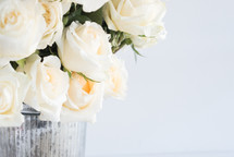 white roses in a metal bucket 