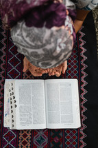 girl kneeling in front of a Bible 
