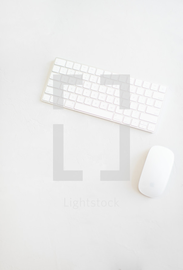computer keyboard and mouse on a white desk 