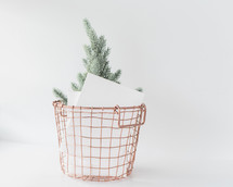 wire basket filled with envelopes and a small Christmas tree 