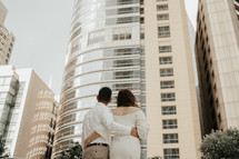bride and groom standing in a city 