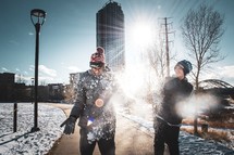 boys playing in snow in a city 