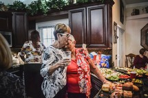 elderly women hugging at a house party 