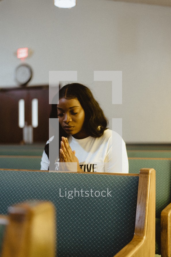 woman praying alone in a church 