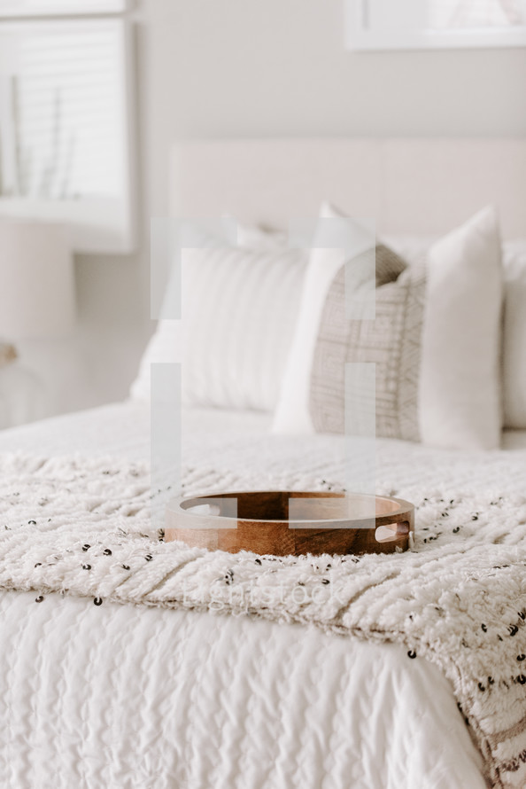 wooden tray on a made bed 