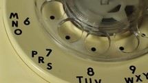 Close up - dialing a number on a vintage rotary telephone