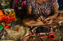 threading beads in a market 