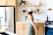woman walking through stylish kitchen 