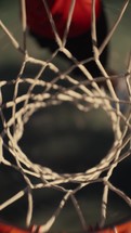 Close up of a basketball being shot on an outdoor basketball court on a sunny day