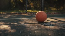 Close up of a basketball on an outdoor basketball court on a sunny day