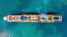 Aerial view of the cruise ship in open water. Passenger cruise ship sailing in ocean top view from above. Large luxury cruise liner deck. 