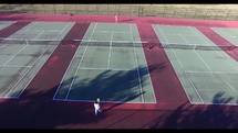 aerial view over people playing tennis on a tennis court 