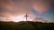 One cross on the green hill with clouds moving on blue starry sky and the sun rising. Easter, resurrection, new life, redemption concept.