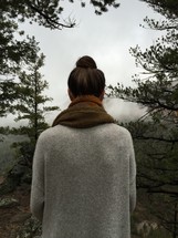 woman with her back to the camera in a sweater and scarf outdoors 