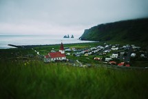 Green moody view of a lonely white church by the ocean in Vik, Iceland