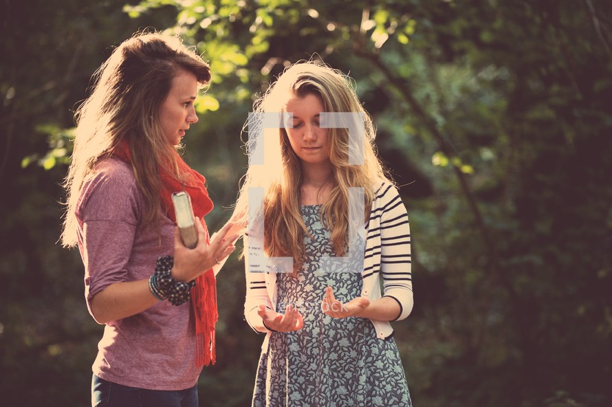 mother and daughter praying together outdoors 
