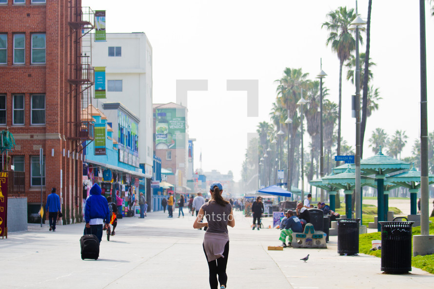 Pedestrians in the sidewalk along a beach front shopping center in Los Angeles.
