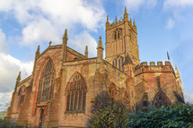 Saint Laurence Church in Ludlow, England is architecturally striking under a blue sky and glows in the late afternoon light