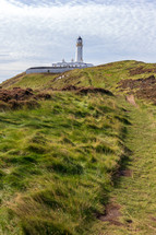 Trail leading to the Mull of Galloway lighthouse in Dumfries and Galloway, Scotland, United Kingdom under a blue sky with white clouds