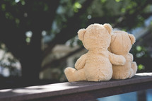 teddy bears with arms around each other 
