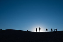 silhouette of a group of people walking 