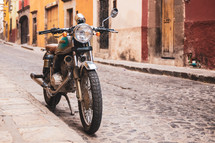 parked motorcycle on a cobblestone street 