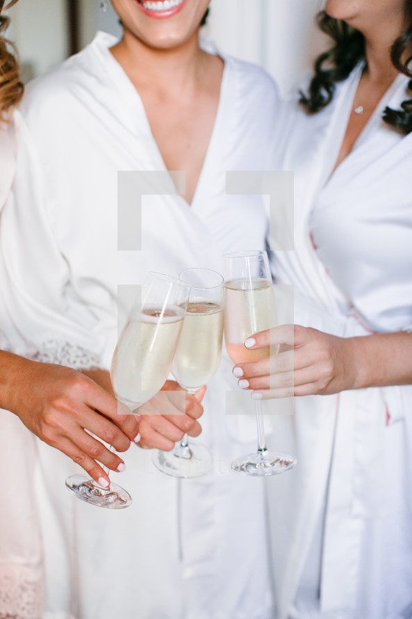bride and bridesmaids toasting champagne 