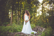 portrait of a bride standing in a forest 