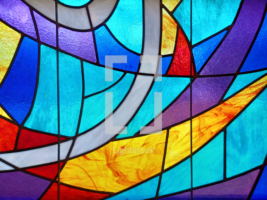 Stained glass window with blue, red, gold and shades of light and dark blue and purple colors. 