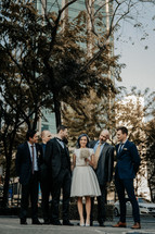 bride, groom, and groomsmen portrait in a city 