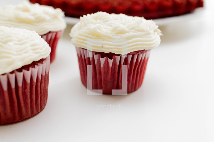 Cupcakes with white icing in red paper cups.