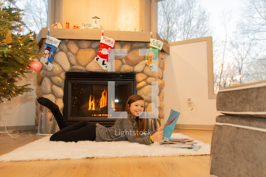 little girl reading a book at Christmas 