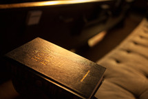 A Bible on a cushioned church pew.