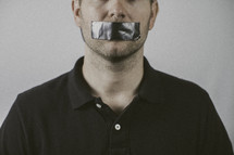 man with duct tape over his mouth 