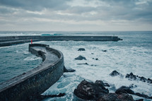 waves and stone wall jetty 