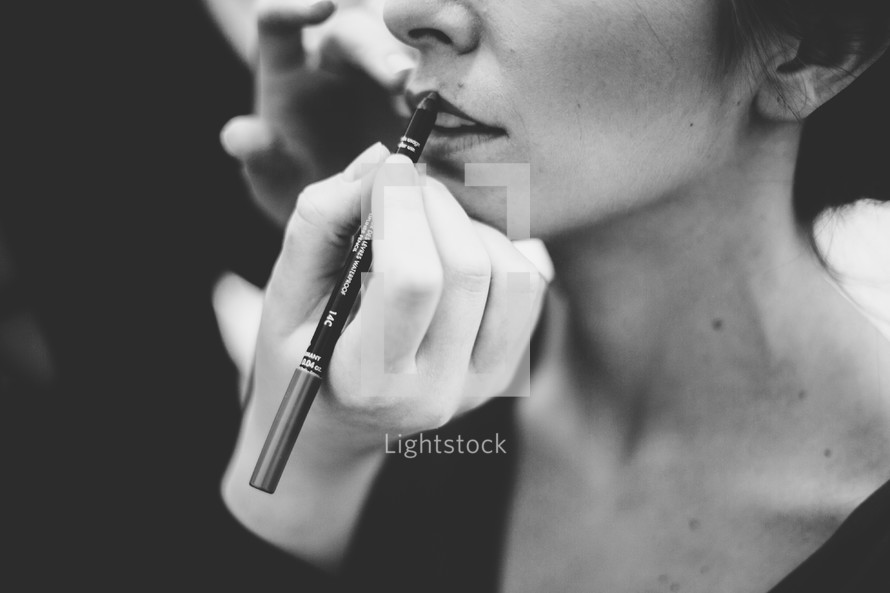 woman putting on lip liner 