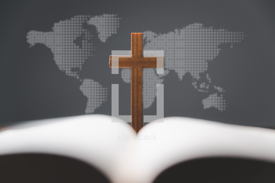 Cross and open Bible in front of a map of the world
